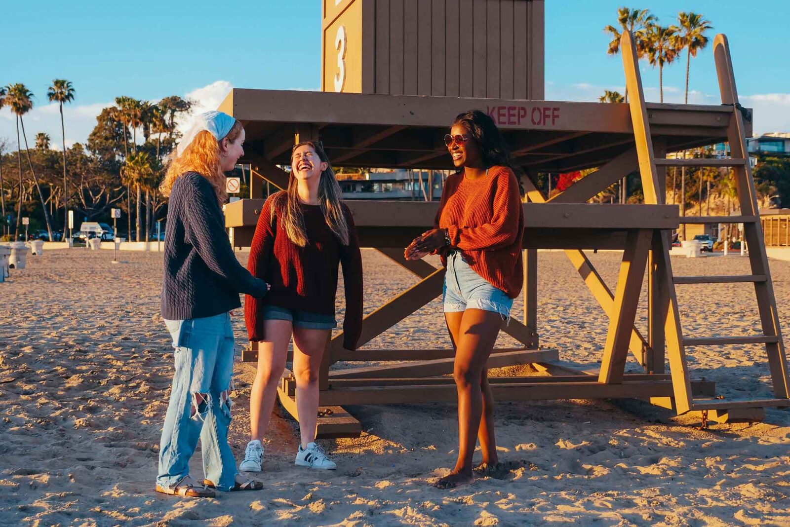 A beach scene of people wearing jorts (jean shorts)